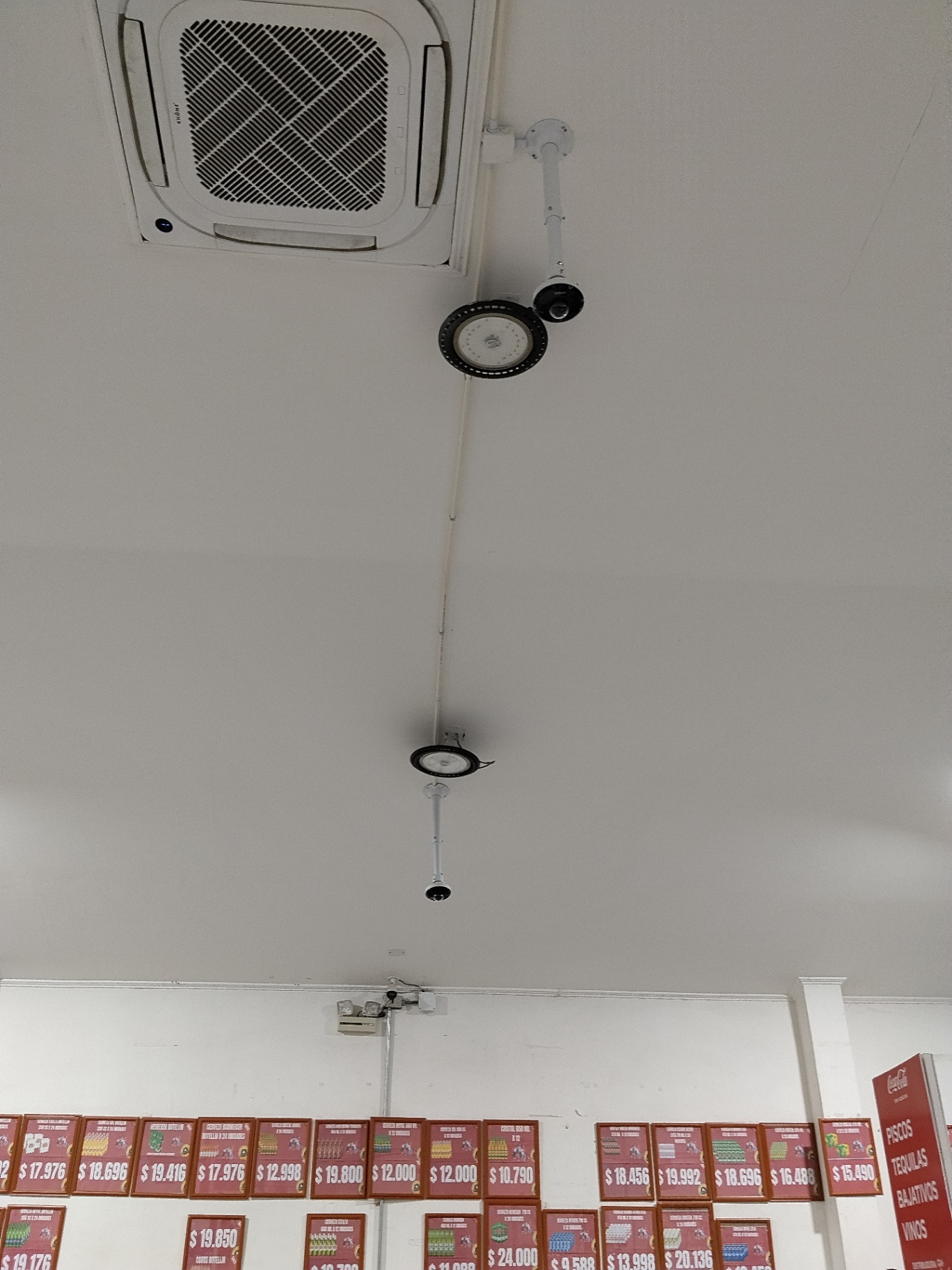 Dos cámaras domo y un sensor de movimiento instalados en el cielo de un local comercial